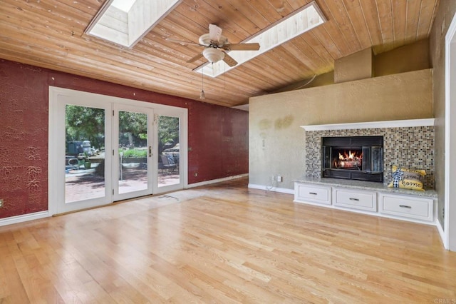 1575 Larson Ln, Fallbrook, CA 92028 - unfurnished living room with a skylight, wooden ceiling, light wood-type flooring, a lit fireplace, and baseboards