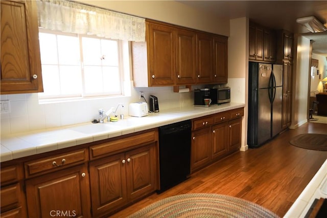 10035 Gierson Ave, Chatsworth, CA 91311 - kitchen featuring black appliances, decorative backsplash, tile countertops, and dark wood finished floors