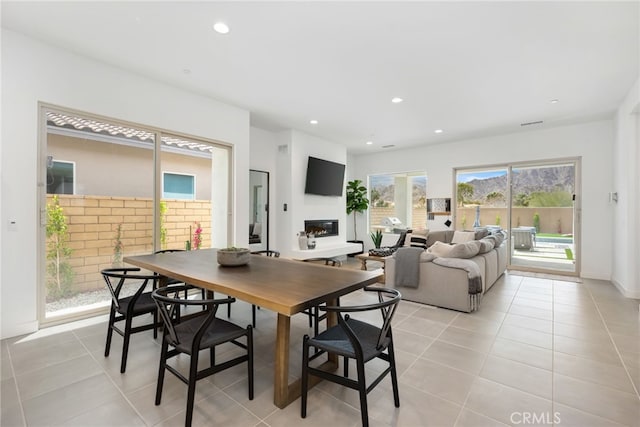 56217 Platinum Way, La Quinta, CA 92253 - dining space with light tile patterned flooring, a glass covered fireplace, and recessed lighting