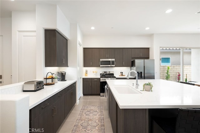 56217 Platinum Way, La Quinta, CA 92253 - kitchen featuring appliances with stainless steel finishes, a sink, decorative backsplash, dark brown cabinets, and light tile patterned flooring