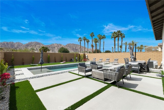 56217 Platinum Way, La Quinta, CA 92253 - fenced backyard featuring a mountain view, a patio area, outdoor lounge area, and central AC