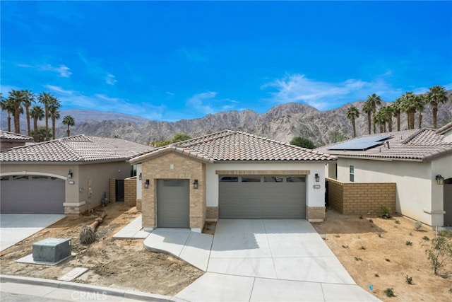 56217 Platinum Way, La Quinta, CA 92253 - view of front of property with a mountain view, a garage, a tiled roof, concrete driveway, and stucco siding