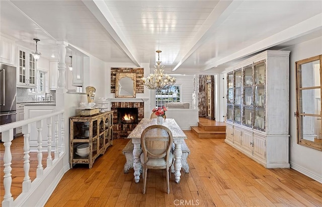 230 Esplanade, San Clemente, CA 92672 - dining area with a chandelier, light wood-style flooring, and a brick fireplace