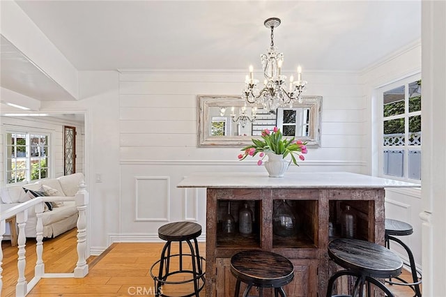 230 Esplanade, San Clemente, CA 92672 - dining space featuring light wood-style flooring, a chandelier, plenty of natural light, a decorative wall, and ornamental molding