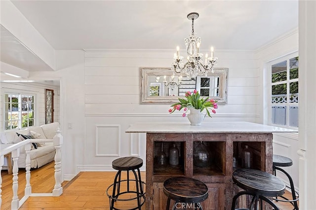 230 Esplanade, San Clemente, CA 92672 - dining area with light wood finished floors, a chandelier, plenty of natural light, a decorative wall, and crown molding
