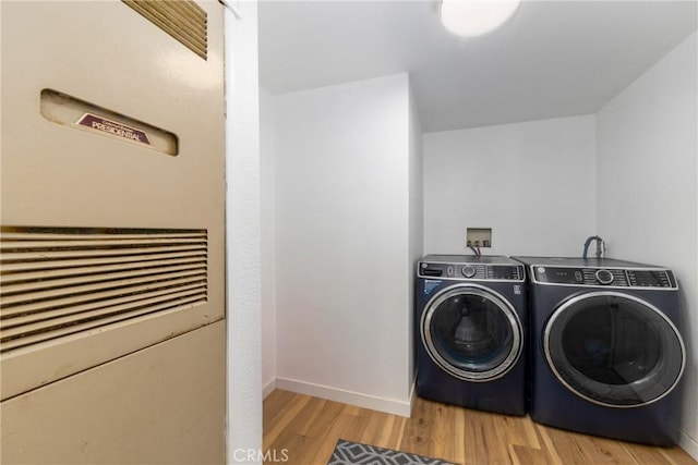 38448 95th St E, Palmdale, CA 93591 - washroom with a heating unit, washer and clothes dryer, light wood-type flooring, and baseboards