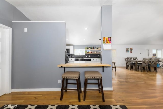 38448 95th St E, Palmdale, CA 93591 - kitchen featuring wood counters, wood finished floors, a breakfast bar, open shelves, and lofted ceiling