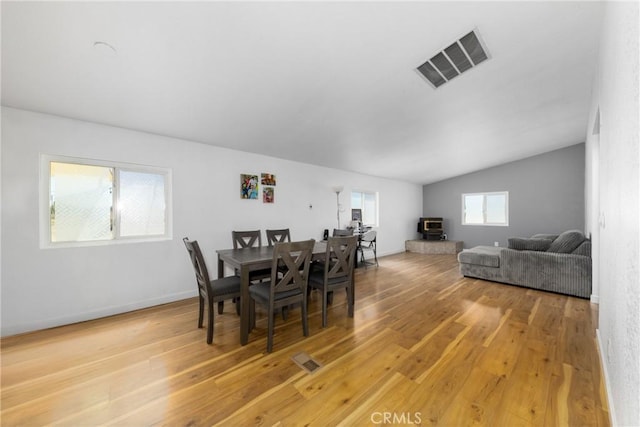 38448 95th St E, Palmdale, CA 93591 - dining space with light wood-style flooring, a wood stove, lofted ceiling, and baseboards