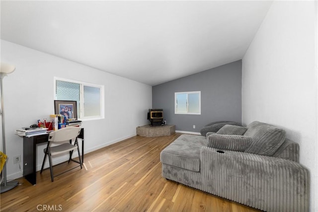 38448 95th St E, Palmdale, CA 93591 - living room featuring a wood stove, wood finished floors, vaulted ceiling, and baseboards