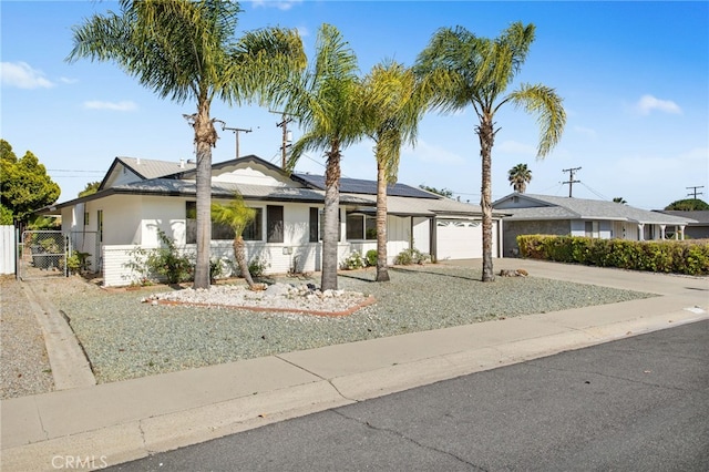 28870 Crosby Dr, Menifee, CA 92586 - ranch-style home featuring an attached garage, driveway, a gate, and roof mounted solar panels