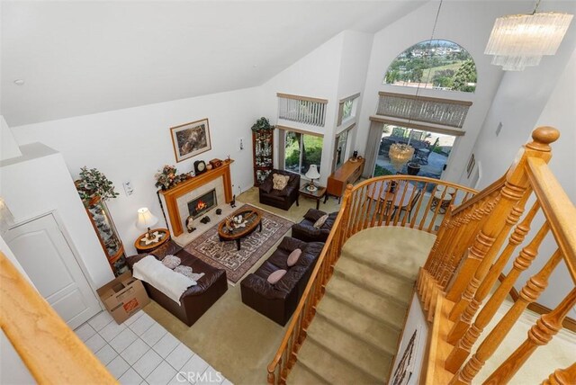 29206 Alfieri St, Laguna Niguel, CA 92677 - tiled living room featuring a chandelier, high vaulted ceiling, carpet, and a fireplace with flush hearth