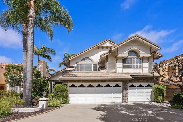 29206 Alfieri St, Laguna Niguel, CA 92677 - traditional home featuring a garage, driveway, a tiled roof, and stone siding