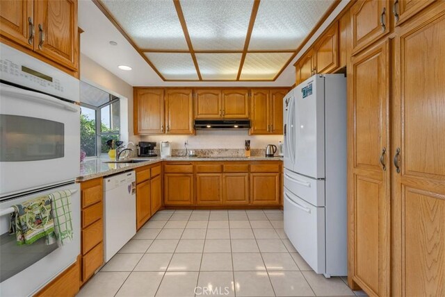 29206 Alfieri St, Laguna Niguel, CA 92677 - kitchen with white appliances, a sink, brown cabinetry, light tile patterned flooring, and under cabinet range hood