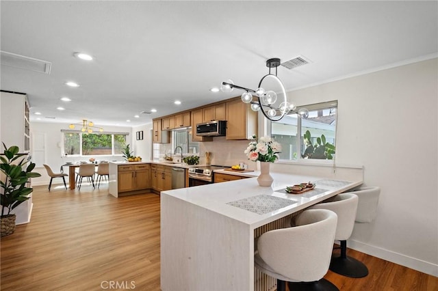 5742 Thelma Ave, La Palma, CA 90623 - kitchen with a peninsula, stainless steel appliances, recessed lighting, light countertops, and light wood-type flooring