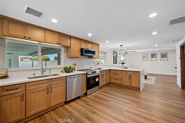 5742 Thelma Ave, La Palma, CA 90623 - kitchen with stainless steel appliances, a sink, a peninsula, light wood-style flooring, and light countertops