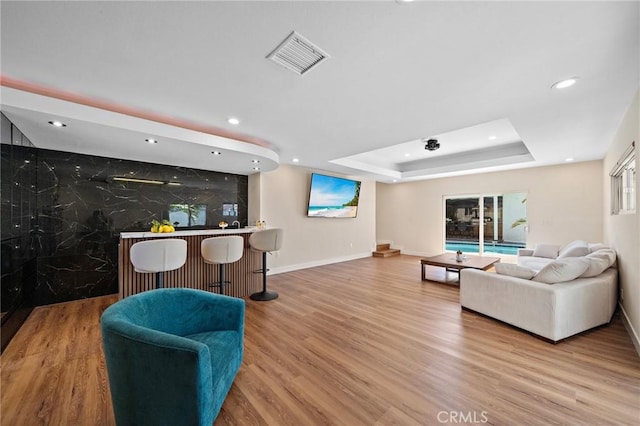 5742 Thelma Ave, La Palma, CA 90623 - living room with a bar, a tray ceiling, recessed lighting, baseboards, and wood finished floors
