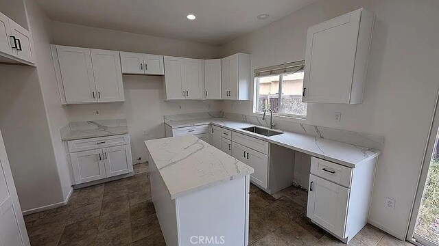 3929 Albillo, Perris, CA 92571 - kitchen with a sink, a center island, white cabinetry, light stone countertops, and recessed lighting