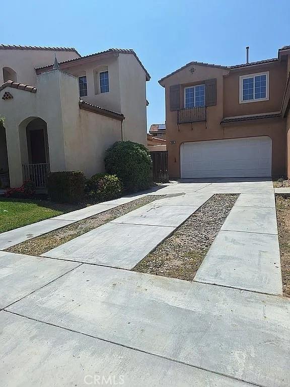 3929 Albillo, Perris, CA 92571 - mediterranean / spanish home featuring a garage, driveway, stucco siding, and a tile roof