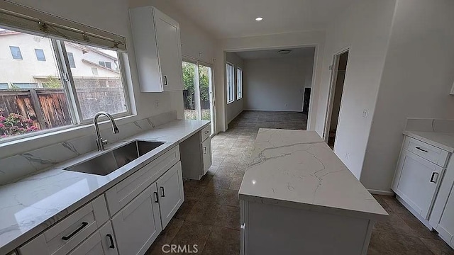3929 Albillo, Perris, CA 92571 - kitchen featuring a sink, white cabinets, light stone counters, a kitchen island, and recessed lighting