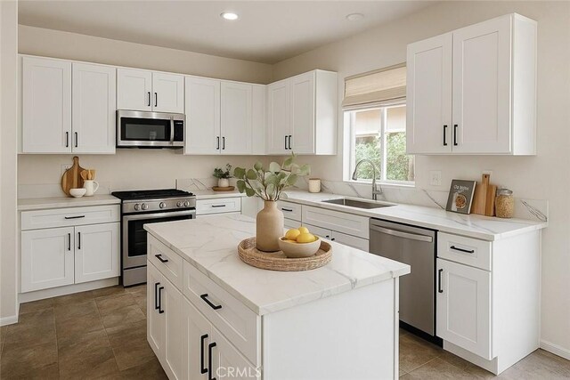 3929 Albillo, Perris, CA 92571 - kitchen featuring appliances with stainless steel finishes, a sink, a center island, light stone counters, and white cabinetry