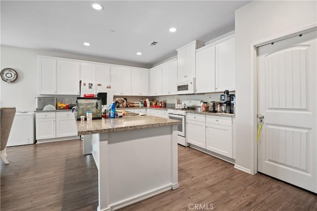 2219 Albatross Way, San Jacinto, CA 92582 - kitchen featuring white appliances, white cabinetry, a center island, dark wood finished floors, and recessed lighting