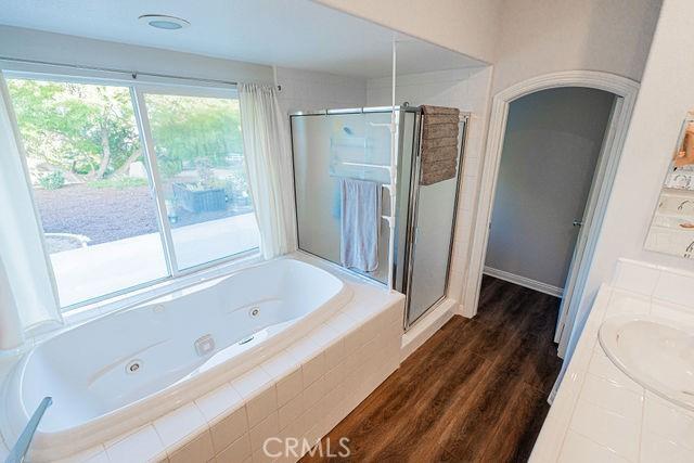 36884 Hidden Trail Ct, Winchester, CA 92596 - full bath with a stall shower, a tub with jets, wood finished floors, and vanity