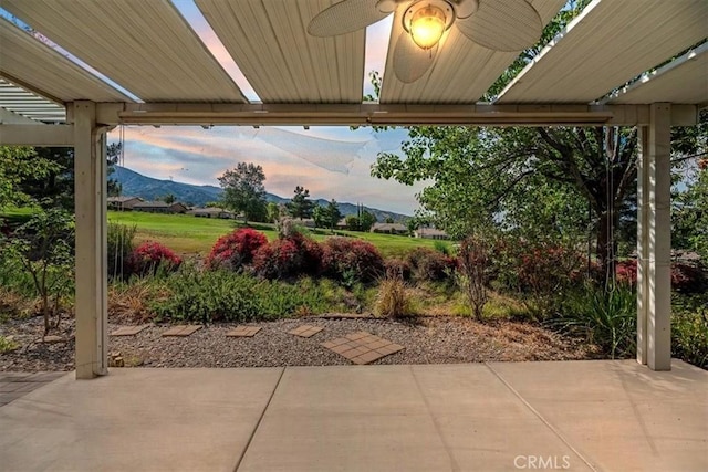 24271 Whitetail Dr, Corona, CA 92883 - patio terrace at dusk featuring a patio area, ceiling fan, and a mountain view