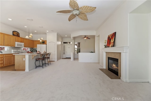 24271 Whitetail Dr, Corona, CA 92883 - kitchen featuring white appliances, ceiling fan, open floor plan, a kitchen bar, and light countertops