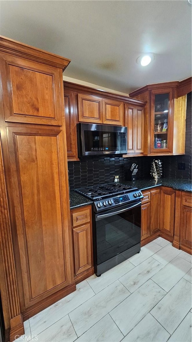 402 Hartzell Ave, Redlands, CA 92374 - kitchen featuring range with gas stovetop, tasteful backsplash, brown cabinetry, and glass insert cabinets