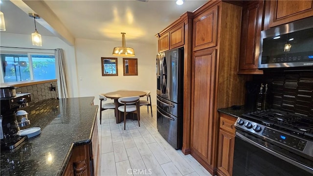 402 Hartzell Ave, Redlands, CA 92374 - kitchen featuring appliances with stainless steel finishes, backsplash, hanging light fixtures, dark stone countertops, and brown cabinets