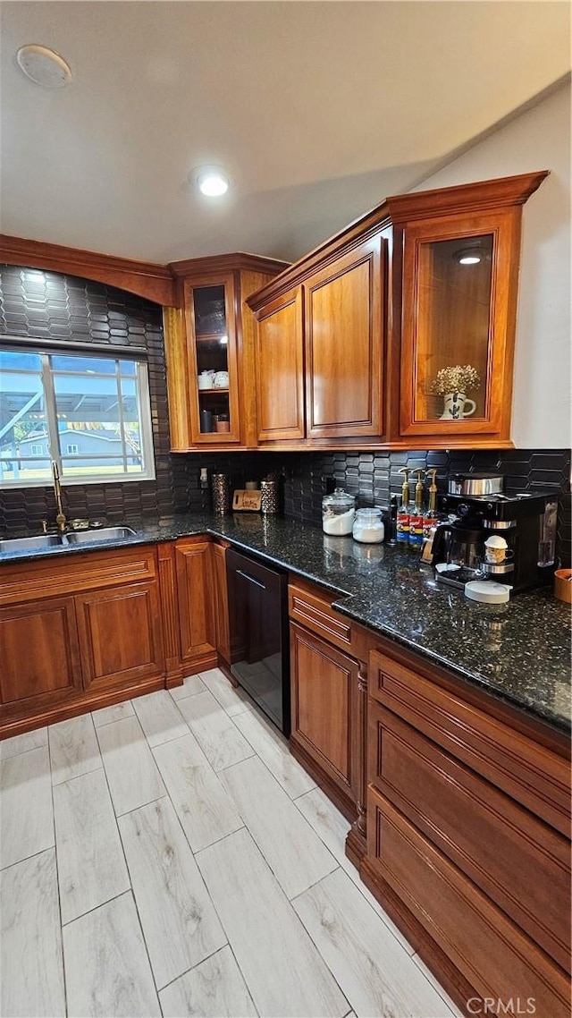 402 Hartzell Ave, Redlands, CA 92374 - kitchen featuring a sink, dishwasher, brown cabinets, tasteful backsplash, and dark stone countertops