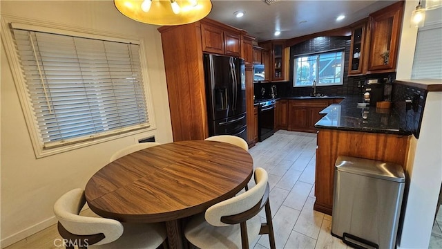 402 Hartzell Ave, Redlands, CA 92374 - kitchen with black fridge, a sink, glass insert cabinets, backsplash, and light wood-type flooring