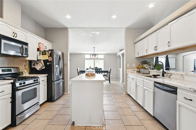 3595 Buchanan St, Riverside, CA 92503 - kitchen featuring appliances with stainless steel finishes, a sink, a kitchen island, white cabinetry, and light tile patterned floors