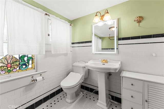 337 S Center St, Redlands, CA 92373 - bathroom featuring tile walls, toilet, a wainscoted wall, and tile patterned flooring