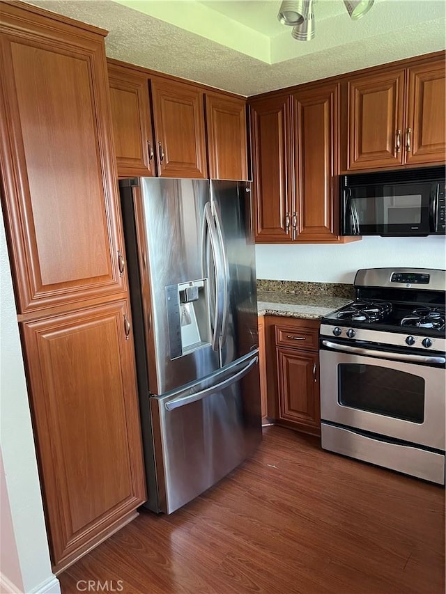 30902 Clubhouse Dr Unit 27H, Laguna Niguel, CA 92677 - kitchen featuring appliances with stainless steel finishes, dark wood-style floors, and brown cabinets