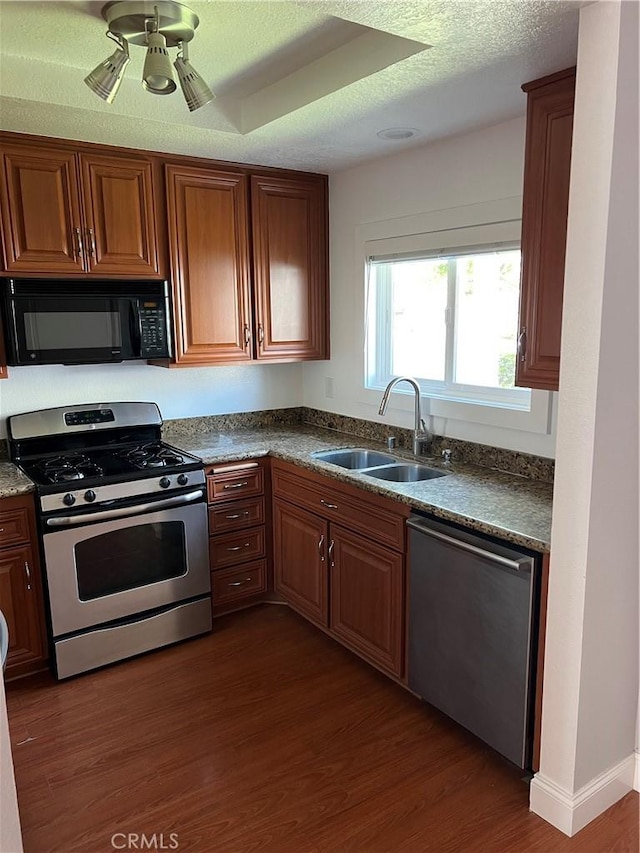 30902 Clubhouse Dr Unit 27H, Laguna Niguel, CA 92677 - kitchen with stainless steel appliances, a sink, dark wood-type flooring, dark countertops, and a textured ceiling