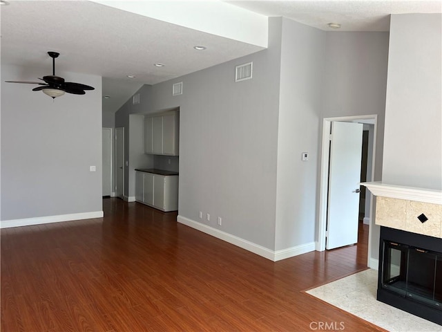 30902 Clubhouse Dr Unit 27H, Laguna Niguel, CA 92677 - unfurnished living room with a ceiling fan, wood finished floors, baseboards, a tiled fireplace, and vaulted ceiling