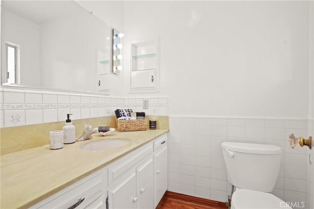 1247 W 17th St, San Pedro, CA 90731 - bathroom with vanity, toilet, tile walls, wood finished floors, and a wainscoted wall