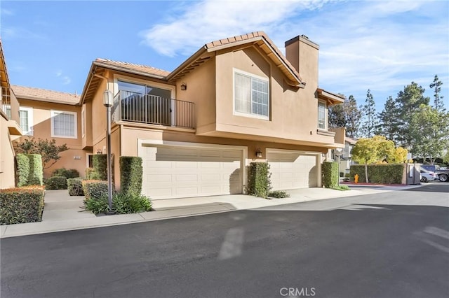 8039 E Snapdragon Ln, Anaheim, CA 92808 - view of property featuring stucco siding, an attached garage, a chimney, concrete driveway, and a tile roof