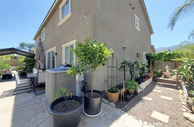 25664 Red Hawk Rd, Corona, CA 92883 - view of side of property featuring stucco siding, a patio, and central AC