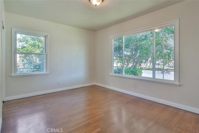 3411 W Chandler Blvd, Burbank, CA 91505 - unfurnished room with baseboards, healthy amount of natural light, and wood finished floors