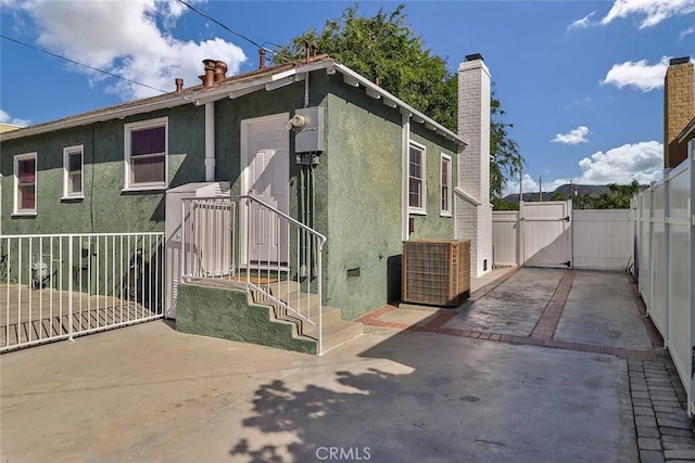 3411 W Chandler Blvd, Burbank, CA 91505 - view of side of property with a gate, a chimney, stucco siding, cooling unit, and a patio