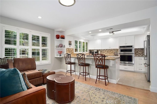 20950 Oxnard St Unit 11, Woodland Hills, CA 91367 - kitchen featuring stainless steel appliances, a peninsula, a tray ceiling, a breakfast bar area, and open floor plan