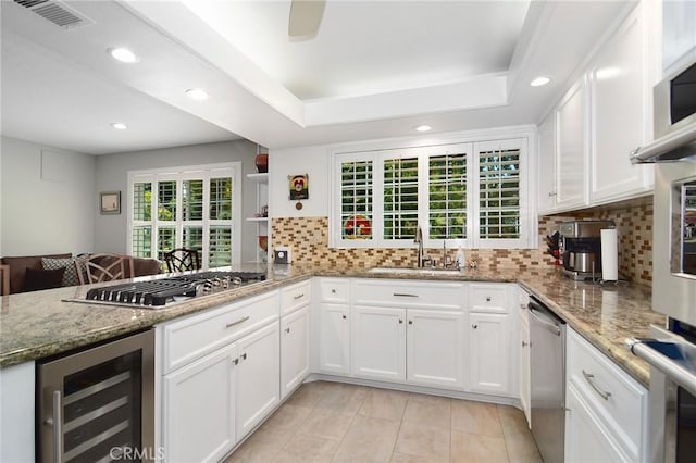 20950 Oxnard St Unit 11, Woodland Hills, CA 91367 - kitchen with wine cooler, a sink, stainless steel appliances, white cabinetry, and recessed lighting