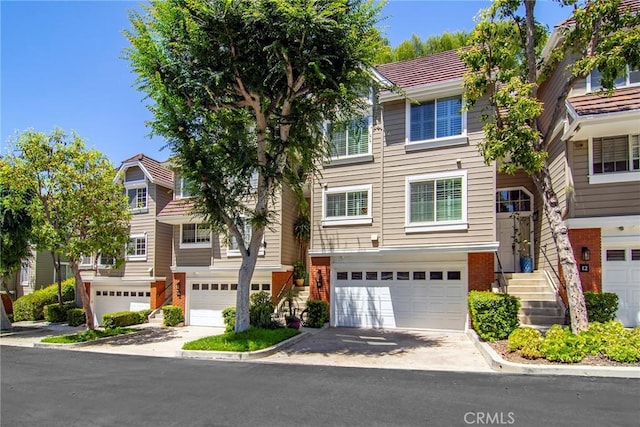 20950 Oxnard St Unit 11, Woodland Hills, CA 91367 - view of property with a garage, brick siding, and driveway