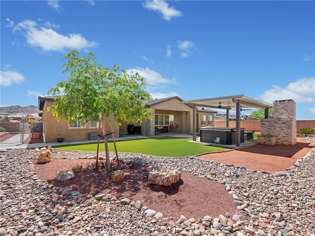 17028 Ta Ki Pi Rd, Apple Valley, CA 92307 - back of house with a hot tub, a patio, stucco siding, ceiling fan, and a gate
