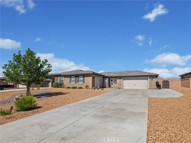 17028 Ta Ki Pi Rd, Apple Valley, CA 92307 - ranch-style home with concrete driveway, a garage, and stucco siding