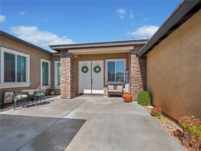 17028 Ta Ki Pi Rd, Apple Valley, CA 92307 - property entrance featuring stone siding, stucco siding, and a patio