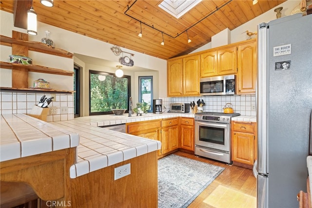 1760 Stuart St, Cambria, CA 93428 - kitchen with stainless steel appliances, wooden ceiling, lofted ceiling, a skylight, and a peninsula