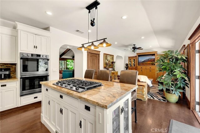 5121 E Lomita Ave, Orange, CA 92869 - kitchen with arched walkways, appliances with stainless steel finishes, dark wood finished floors, a ceiling fan, and recessed lighting